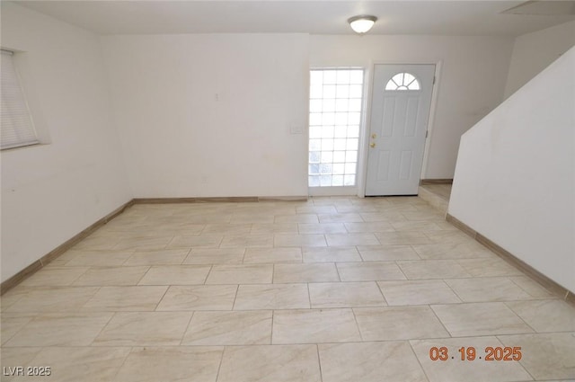 foyer with plenty of natural light and baseboards