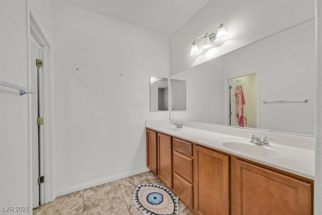 full bathroom featuring double vanity, baseboards, and a sink
