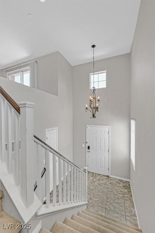 1121 Via Castelli, Henderson, NV 89052 - foyer entrance featuring stairs, a notable chandelier, a towering ceiling, and baseboards