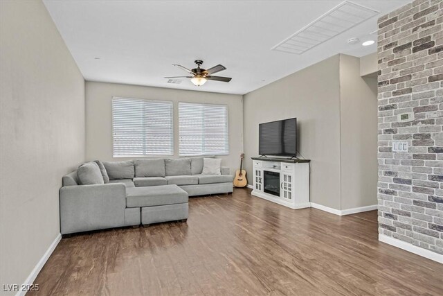 living area with wood finished floors, ceiling fan, and baseboards