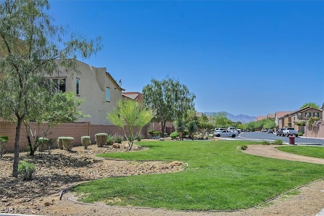 view of home's community featuring fence, a residential view, and a yard
