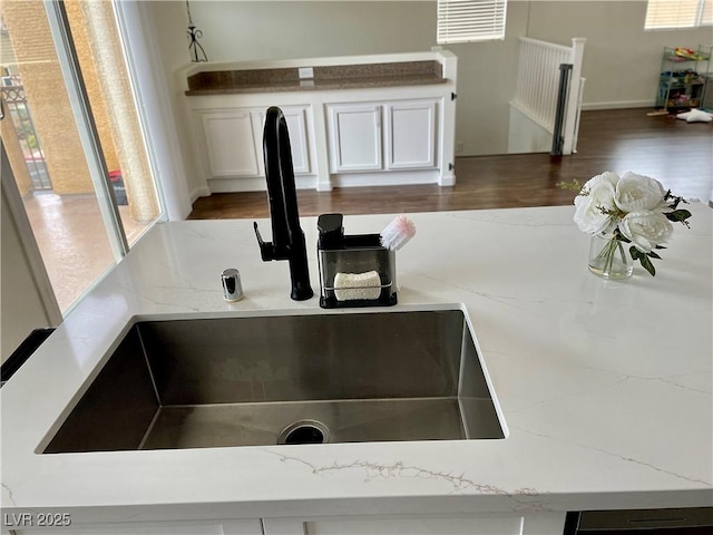 1121 Via Castelli, Henderson, NV 89052 - room details featuring light stone counters, white cabinets, a sink, and wood finished floors