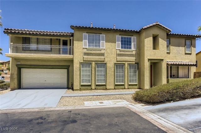 view of front of home featuring a tile roof, a garage, a balcony, driveway, and stucco siding