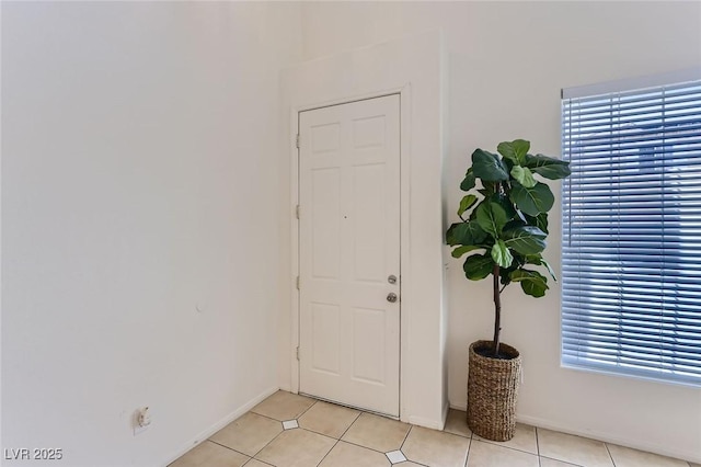 foyer entrance featuring baseboards and light tile patterned floors