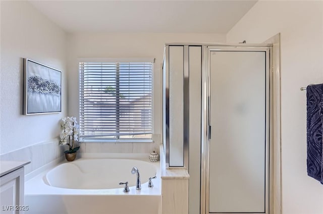 bathroom featuring a stall shower, a healthy amount of sunlight, and a garden tub