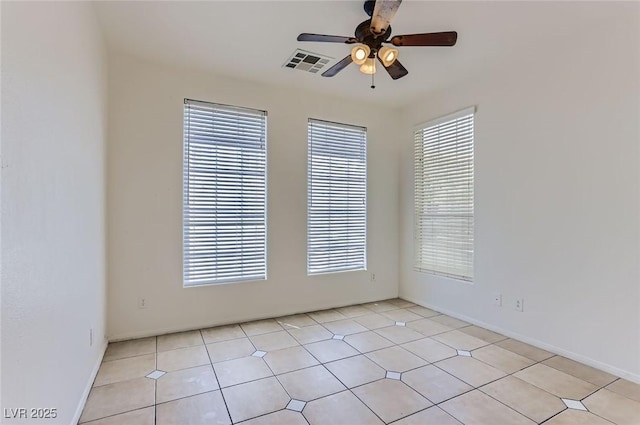 spare room with baseboards, visible vents, and ceiling fan