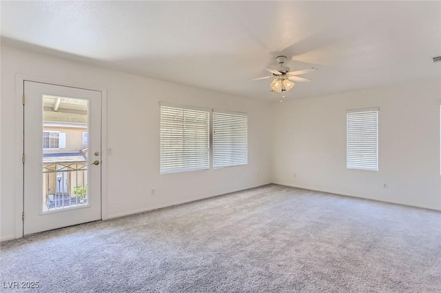 empty room with ceiling fan, a healthy amount of sunlight, and carpet flooring