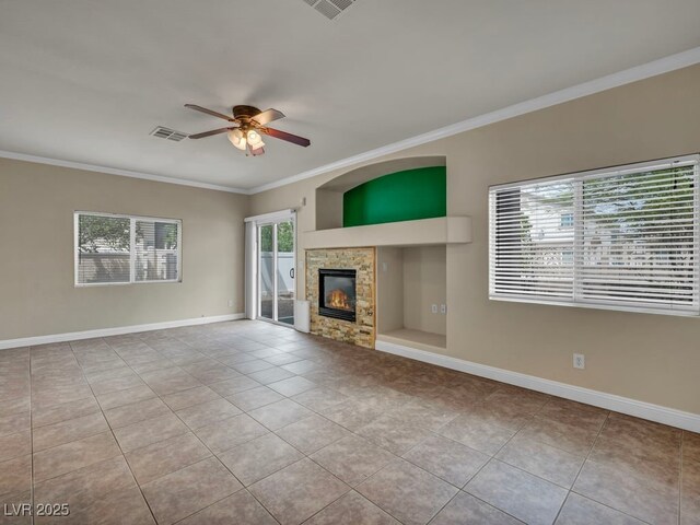 8728 Tom Noon Ave Unit 103, Las Vegas, NV 89178 - unfurnished living room with visible vents, crown molding, ceiling fan, tile patterned flooring, and a stone fireplace