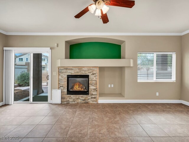 8728 Tom Noon Ave Unit 103, Las Vegas, NV 89178 - unfurnished living room with a ceiling fan, ornamental molding, a healthy amount of sunlight, a glass covered fireplace, and tile patterned flooring