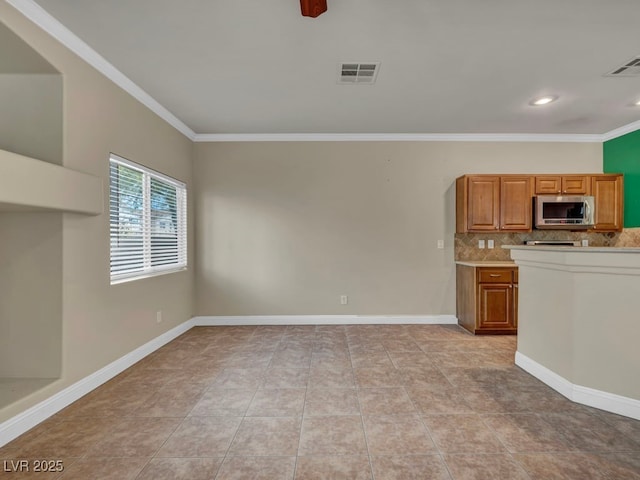 8728 Tom Noon Ave Unit 103, Las Vegas, NV 89178 - kitchen featuring crown molding, visible vents, stainless steel microwave, and backsplash