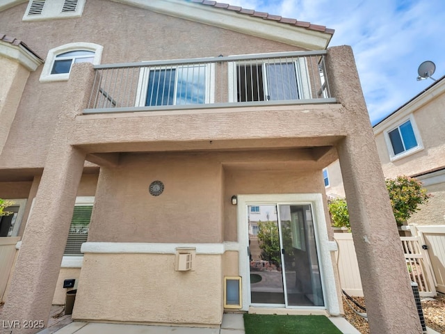 8728 Tom Noon Ave Unit 103, Las Vegas, NV 89178 - back of house featuring stucco siding, fence, and a balcony