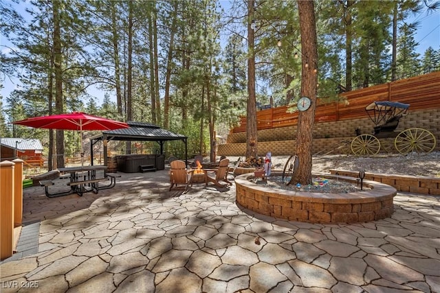 view of patio / terrace featuring fence, a gazebo, and a hot tub