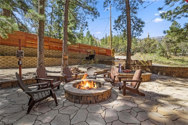view of patio with fence and a fire pit