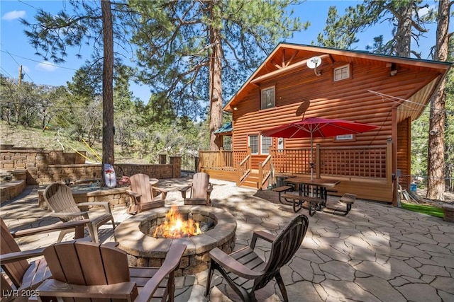 view of patio / terrace featuring a deck and a fire pit