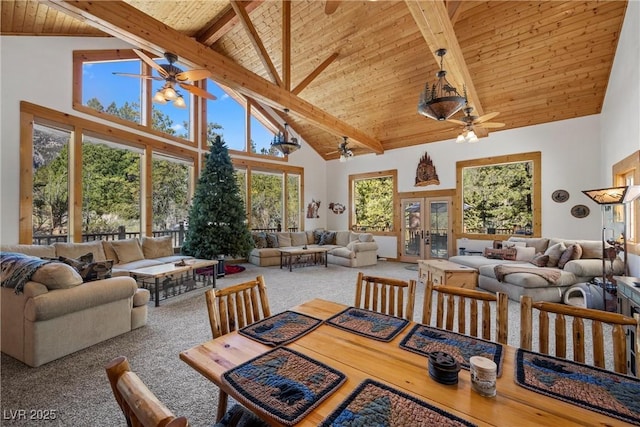 carpeted dining area with beamed ceiling, high vaulted ceiling, wooden ceiling, french doors, and a ceiling fan