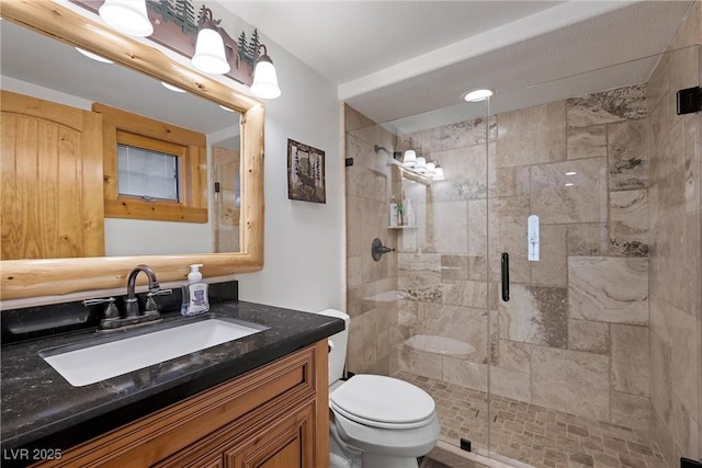bathroom with vanity, a stall shower, and toilet