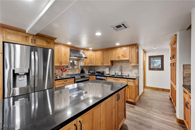 kitchen featuring a sink, extractor fan, stainless steel appliances, baseboards, and visible vents