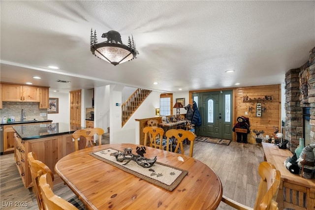 dining room featuring a textured ceiling, visible vents, light wood-type flooring, stairway, and recessed lighting