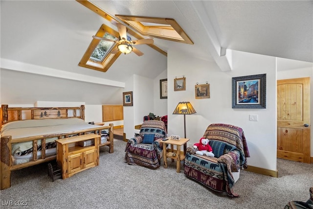 carpeted bedroom featuring a ceiling fan, baseboards, and vaulted ceiling with skylight