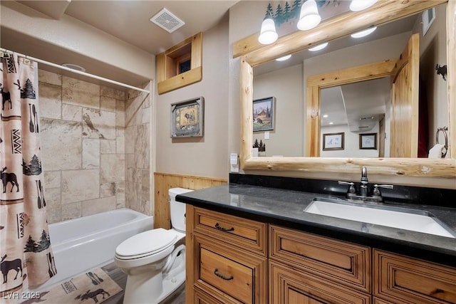 full bath with toilet, visible vents, wainscoting, and vanity