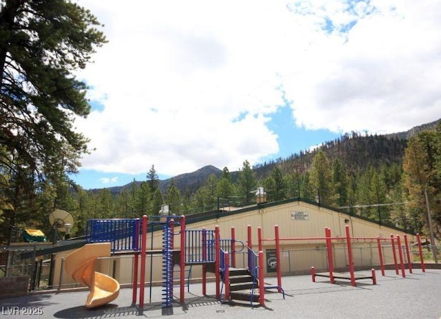community jungle gym featuring a mountain view and a wooded view