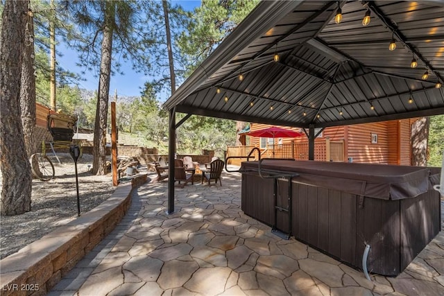 view of patio / terrace with fence, a gazebo, and a hot tub