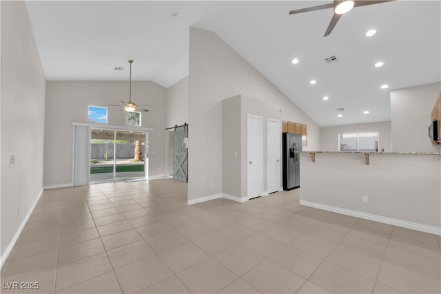 2514 Tropical Sands Ave, North Las Vegas, NV 89031 - unfurnished living room featuring a barn door, high vaulted ceiling, a ceiling fan, baseboards, and visible vents