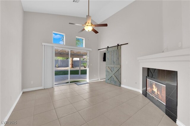 2514 Tropical Sands Ave, North Las Vegas, NV 89031 - unfurnished living room with ceiling fan, a barn door, high vaulted ceiling, baseboards, and tile patterned floors