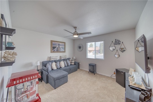 living room with ceiling fan, baseboards, and light carpet