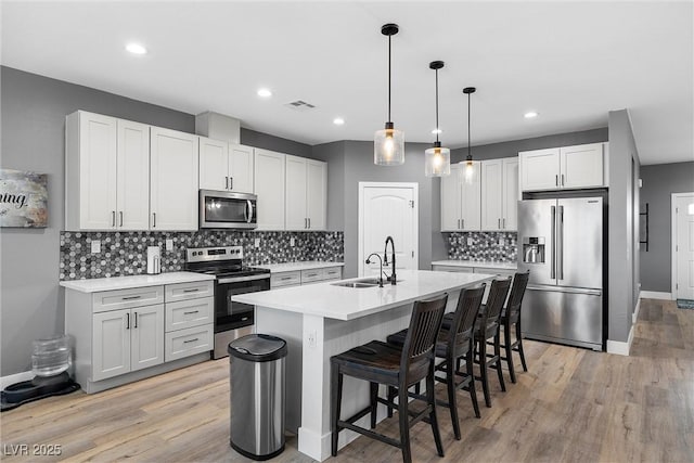 3660 Stirrup, Pahrump, NV 89048 - kitchen with a sink, stainless steel appliances, a breakfast bar, visible vents, and light countertops