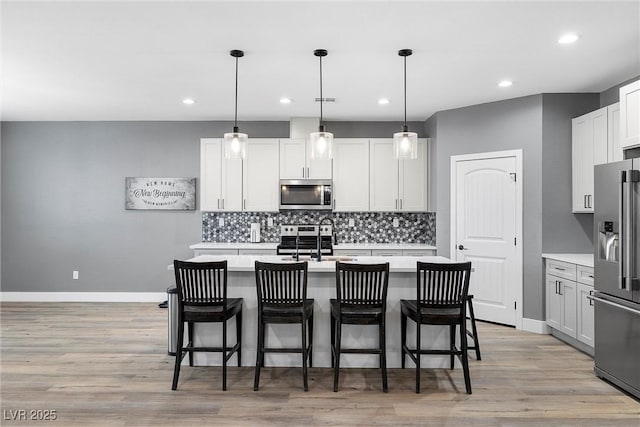 3660 Stirrup, Pahrump, NV 89048 - kitchen featuring light wood finished floors, backsplash, stainless steel appliances, and light countertops
