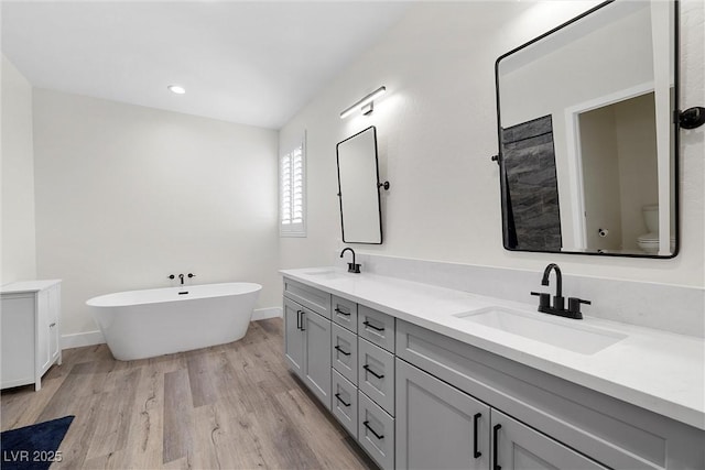 3660 Stirrup, Pahrump, NV 89048 - bathroom with a sink, double vanity, toilet, a freestanding tub, and wood finished floors
