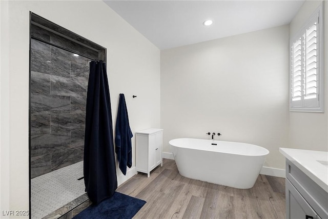 3660 Stirrup, Pahrump, NV 89048 - full bath featuring baseboards, a freestanding tub, wood finished floors, vanity, and tiled shower