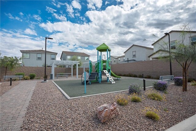 community jungle gym with fence, a pergola, and a residential view