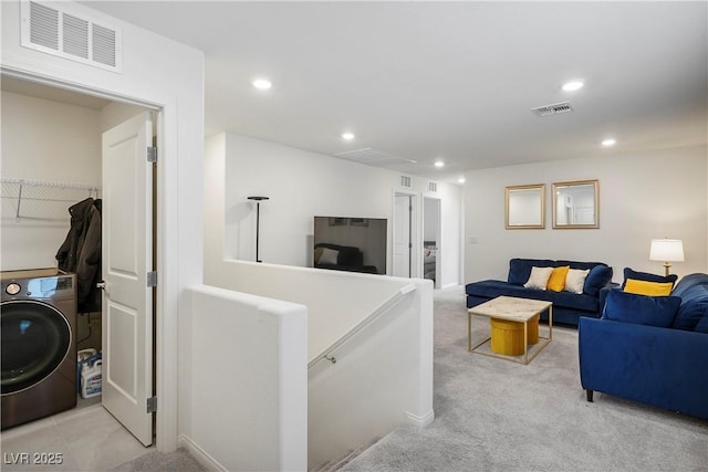 living room featuring recessed lighting, washer / dryer, light carpet, and visible vents