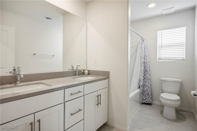 bathroom with a sink, toilet, double vanity, and visible vents