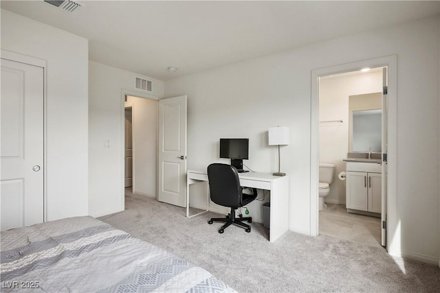 bedroom with connected bathroom, light colored carpet, and visible vents