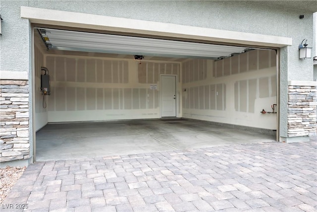 garage featuring decorative driveway and a garage door opener