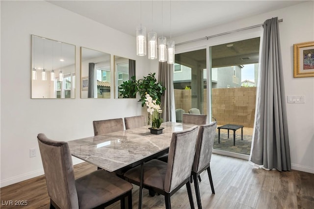 dining space featuring baseboards and wood finished floors