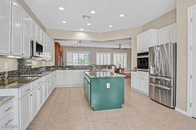 2132 Twin Falls Dr, Henderson, NV 89044 - kitchen featuring appliances with stainless steel finishes, white cabinets, recessed lighting, dark stone counters, and a peninsula