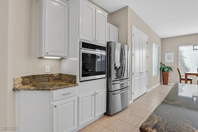 2132 Twin Falls Dr, Henderson, NV 89044 - kitchen with appliances with stainless steel finishes, light tile patterned flooring, white cabinets, dark stone countertops, and baseboards