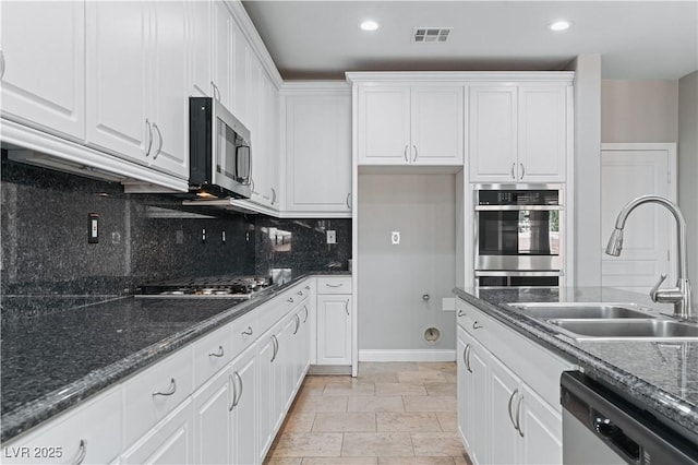 kitchen with visible vents, stainless steel appliances, white cabinets, and a sink