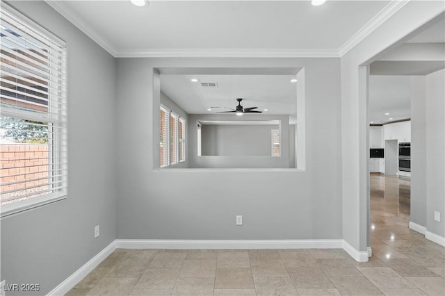 unfurnished room with baseboards, a ceiling fan, visible vents, and a wealth of natural light