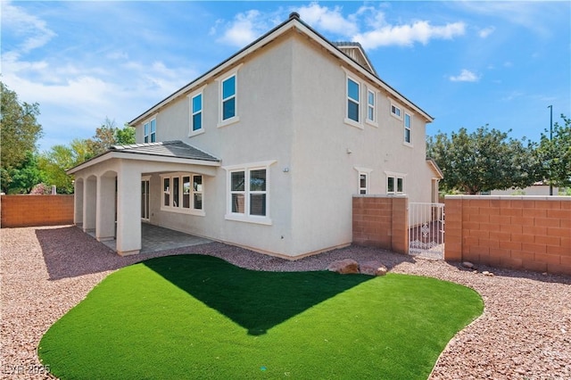 back of house with a patio, a fenced backyard, stucco siding, and a yard