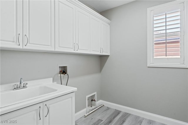 clothes washing area with washer hookup, light wood finished floors, cabinet space, and baseboards