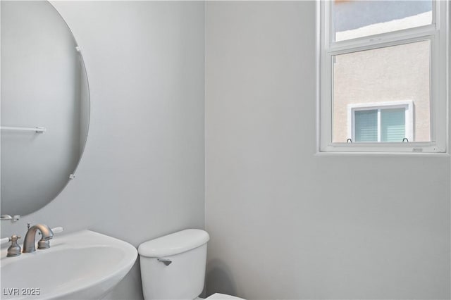 half bathroom featuring toilet and a sink