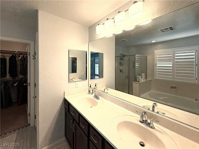 full bath with visible vents, a shower stall, a bath, and a sink