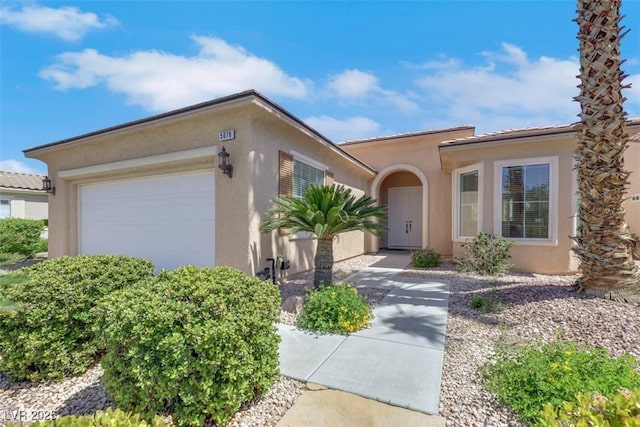 mediterranean / spanish-style house with an attached garage and stucco siding