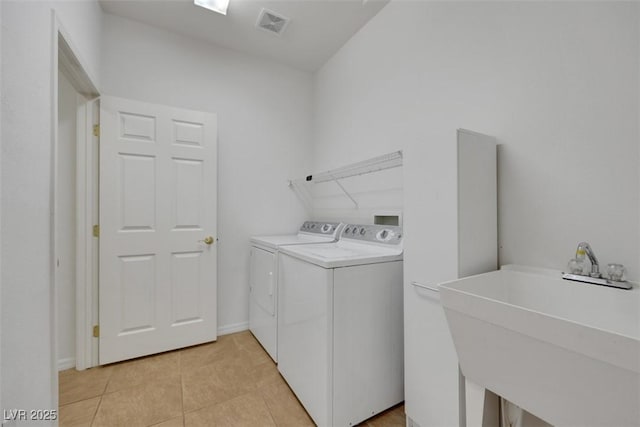 laundry room with a sink, washer and clothes dryer, light tile patterned floors, laundry area, and visible vents
