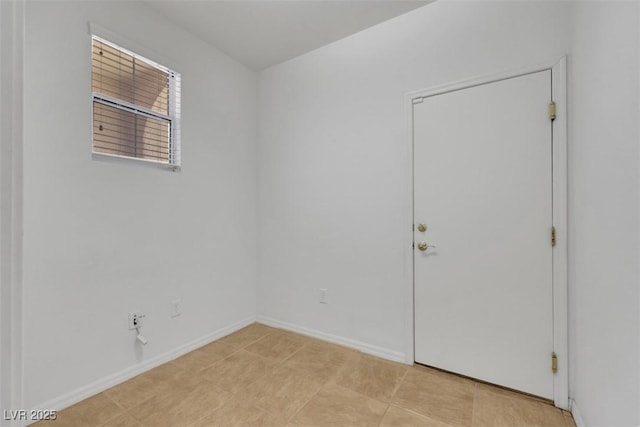 unfurnished room with light tile patterned floors and baseboards